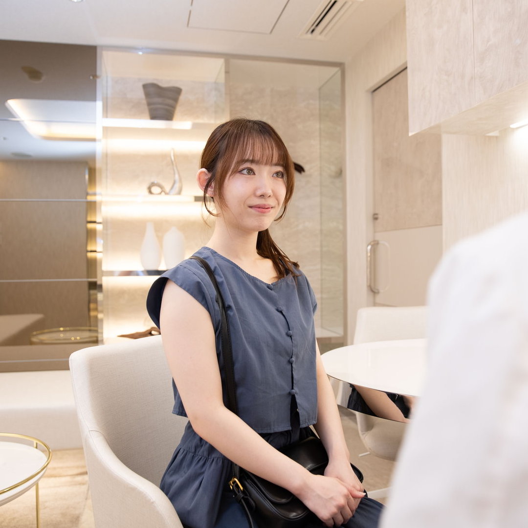 切るフェイスリフトと糸リフトの違いについて説明を聞いている女性